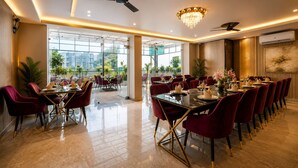 A spacious dining area with a high ceiling, modern chandelier, and a ceiling fan. - SUNBURRY HOTEL TAPOVAN RISHIKESH (Rishikesh)