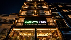 A multi-story building with a sign for Sunbury Hotel, featuring AC rooms, a restaurant, a rooftop, and a cafe. - SUNBURRY HOTEL TAPOVAN RISHIKESH (Rishikesh)