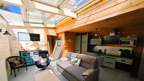 A compact living space with a sofa, a small table, a kitchenette, and a dining area. - Le Chalet Sablais 150m from the beach (Les Sables-d´Olonne)