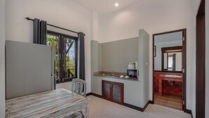 A room with a dining table, a sink, and a mirror. - 1 Bedroom with living room and kittchenette 700meters to Rawai beach (Phuket)
