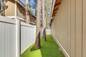 A narrow pathway flanked by wooden fences and trees, leading to a building with a sloped roof. - Big Bear Nature Escape! Cabin 7 Mi to Lake (Big Bear)