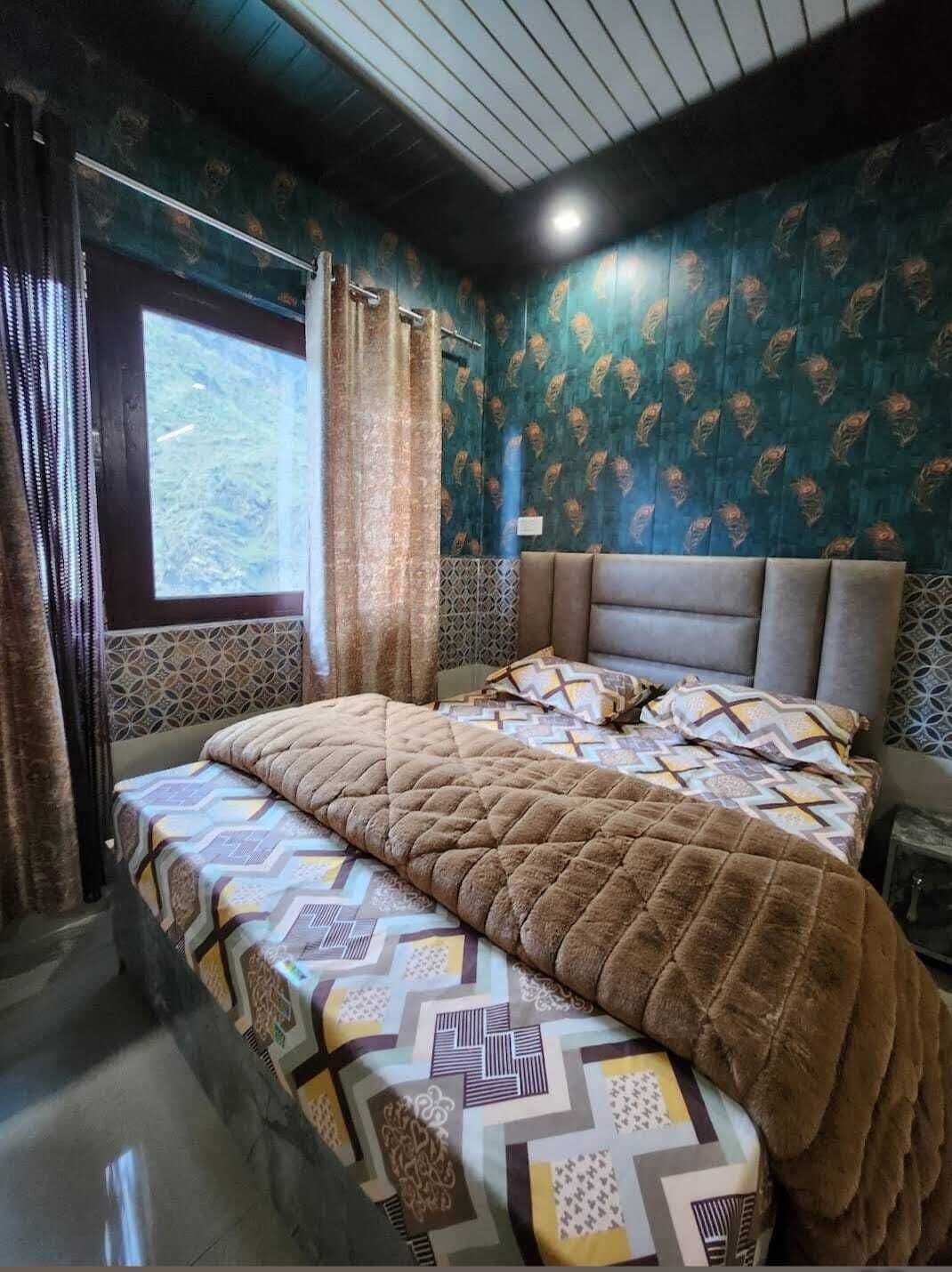 Un dormitorio con pared estampada, un ventanal grande y una cama con colcha.