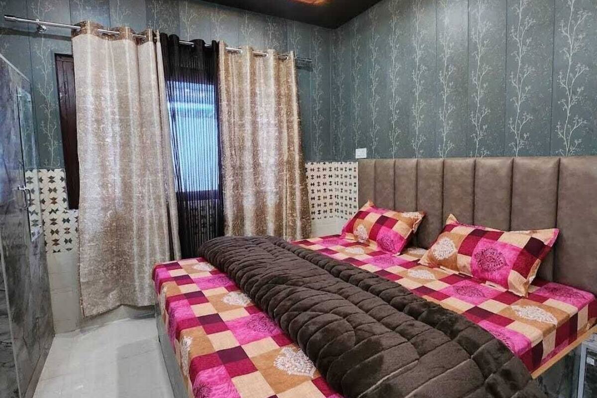 A bedroom with a bed, curtains, and a headboard.