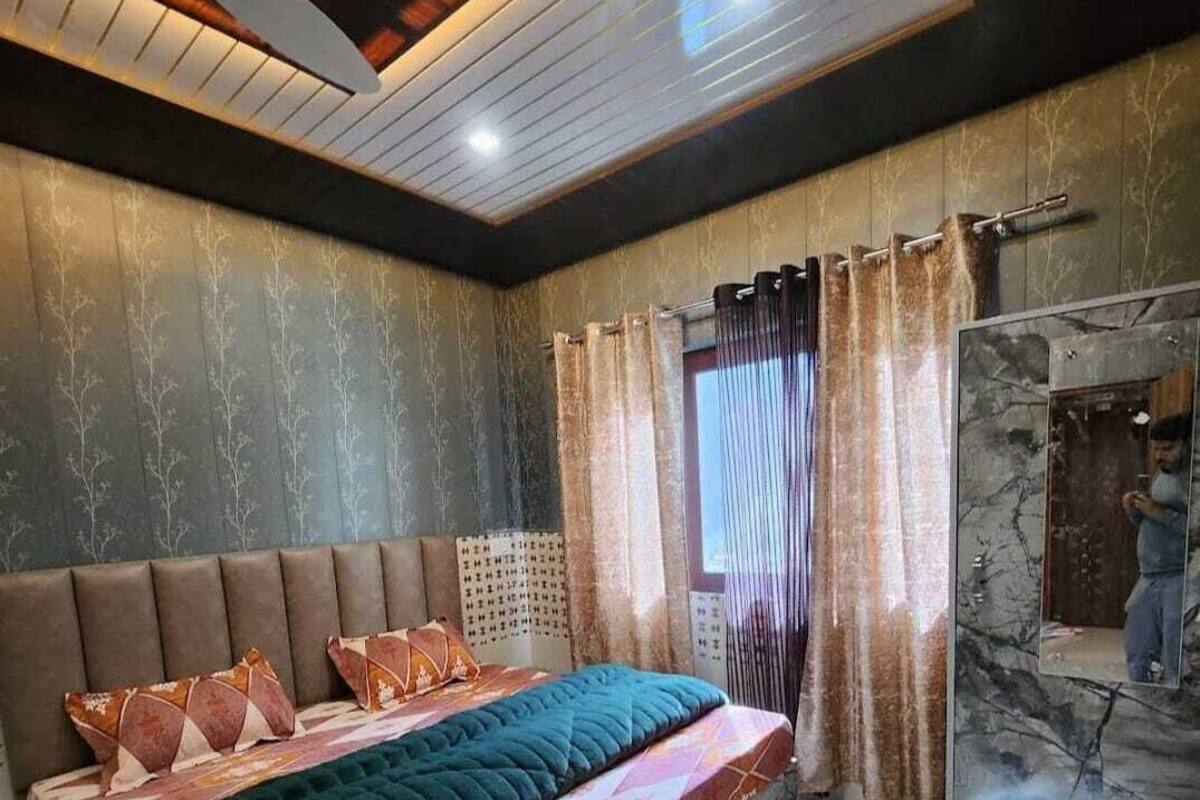 A bedroom with a bed, curtains, a headboard, and a ceiling fan.