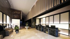 A modern lobby with a reception desk, seating area, and a staircase. - SFEEL Design Hotel Hangzhou Xihu (Hangzhou)
