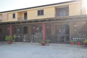 A two-story building with a balcony, a covered patio area, and potted plants. - Vacation Home in Giarratana with 4 bedrooms sleeps 7 (Giarratana)