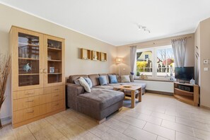 Ein Wohnzimmer mit Sofa, Fernsehschrank und Holzschrank.