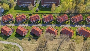 A residential area with multiple houses, each with a red roof, arranged in rows along a street. - Modern semi-detached house just a few meters from the Baltic Sea beach - Am Deich (Zingst)