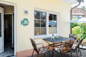 Ein Zimmer mit Tisch, Stühlen, einem Fenster und einer Tür.
