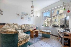 A living room with a sofa, a coffee table, a TV, and a bookshelf. - Semi-detached house close to the beach with 2 bedrooms in Zingst - Am Deich (Zingst)
