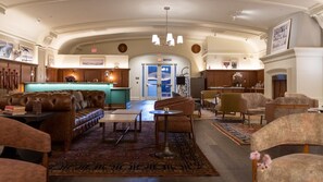 Eine großzügige Lobby mit Ledersofas, einem Empfangstresen und einem Kamin.
