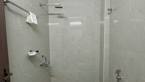 A small, modern bathroom with a toilet, bidet, and shower. - Yellow Sapphire Hotel DLF Cyber City (Hyderabad)