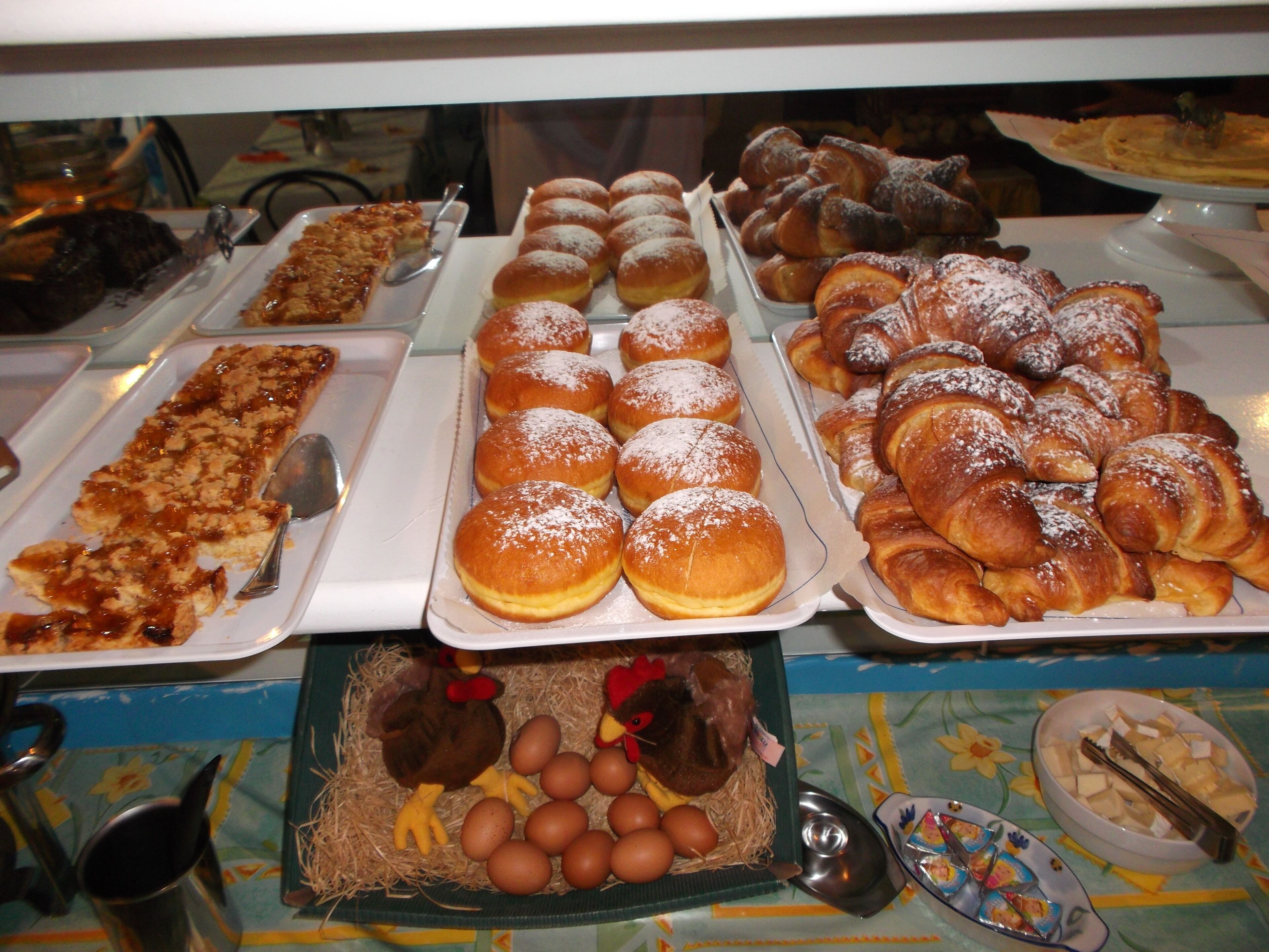 Un buffet con diversi prodotti da forno e un vassoio con uova e pulcini.