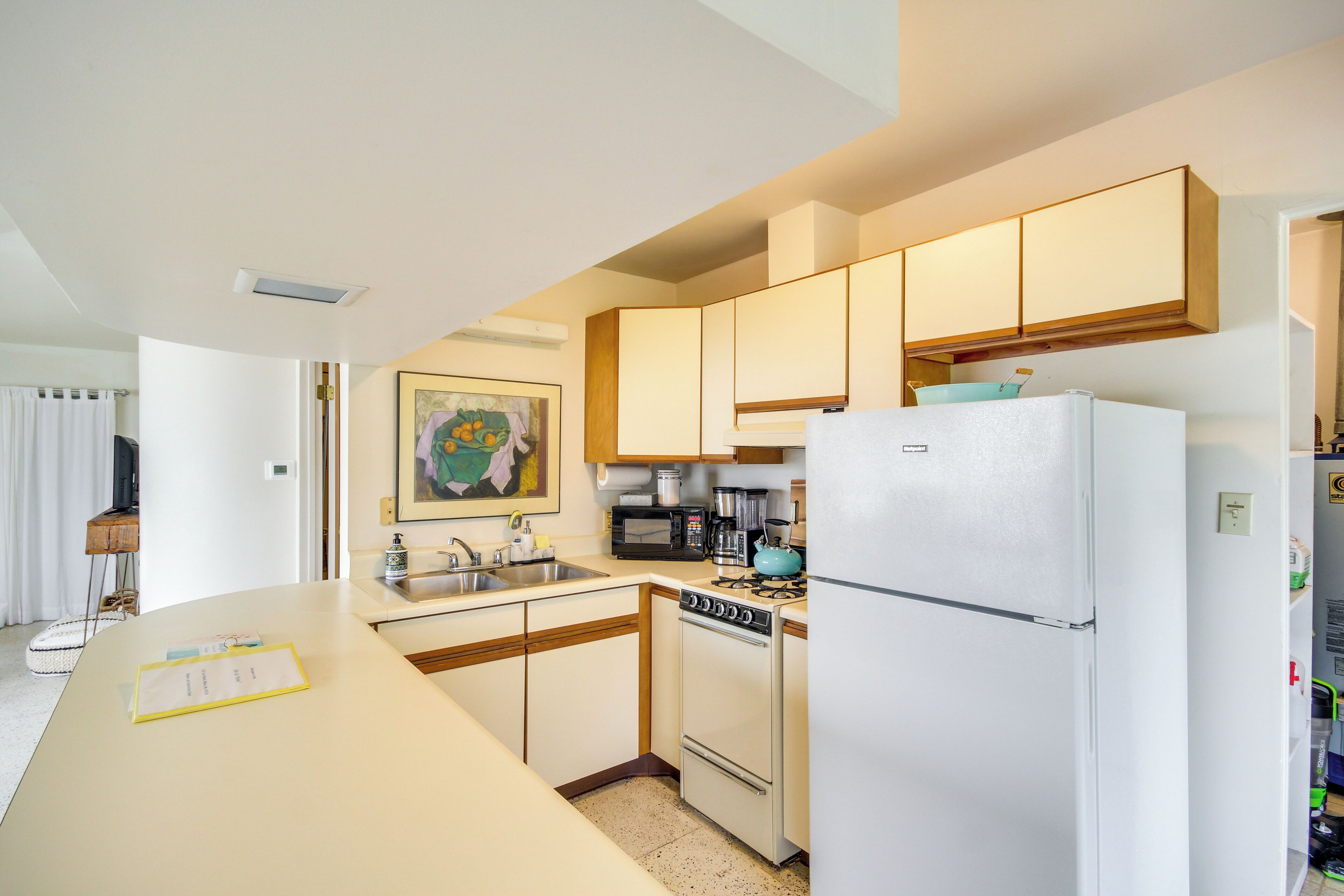 A kitchen with a stove, microwave, refrigerator, and a sink.