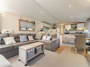 Ein modernes Wohnzimmer mit einer Couch, einem Couchtisch und einem Essbereich mit einem Stuhl.