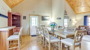 A dining area with a wooden table and chairs, a red cabinet, and a door leading to another room. - Sleeps 14 | Hot Tub, Game Room & 4 King Beds (Ellijay)