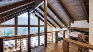 A spacious loft bedroom with a wooden ceiling and large windows overlooking a mountainous landscape. - Game Room & Mtn Views: Large Cle Elum Lake House (Ronald)