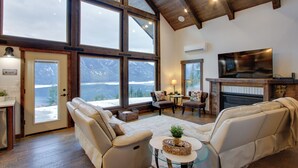 A spacious living room with large windows, a fireplace, and comfortable seating. - Game Room & Mtn Views: Large Cle Elum Lake House (Ronald)