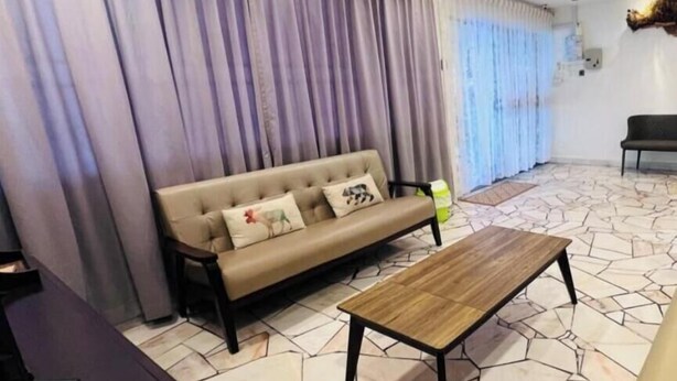 Una sala de estar con un sofá, una mesa de centro y cortinas.