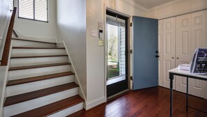 A staircase leading to a door, a light fixture, and a table with a sign. - Lake Living & Game Room! Group Escape 3 Mi to HPU (High Point)