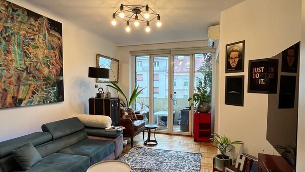 A modern living room with a sectional sofa, a coffee table, a rug, and a vintage radio. - 120sqm Downtown luxury flat big S-side balcony (Wien)