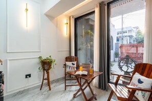 Ein Balkon mit Holzmöbeln, einem Topfpflanzen und Blick auf die Straße.