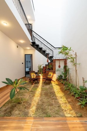 Ein modernes Interieur mit Treppe, Holzboden und Topfpflanzen.