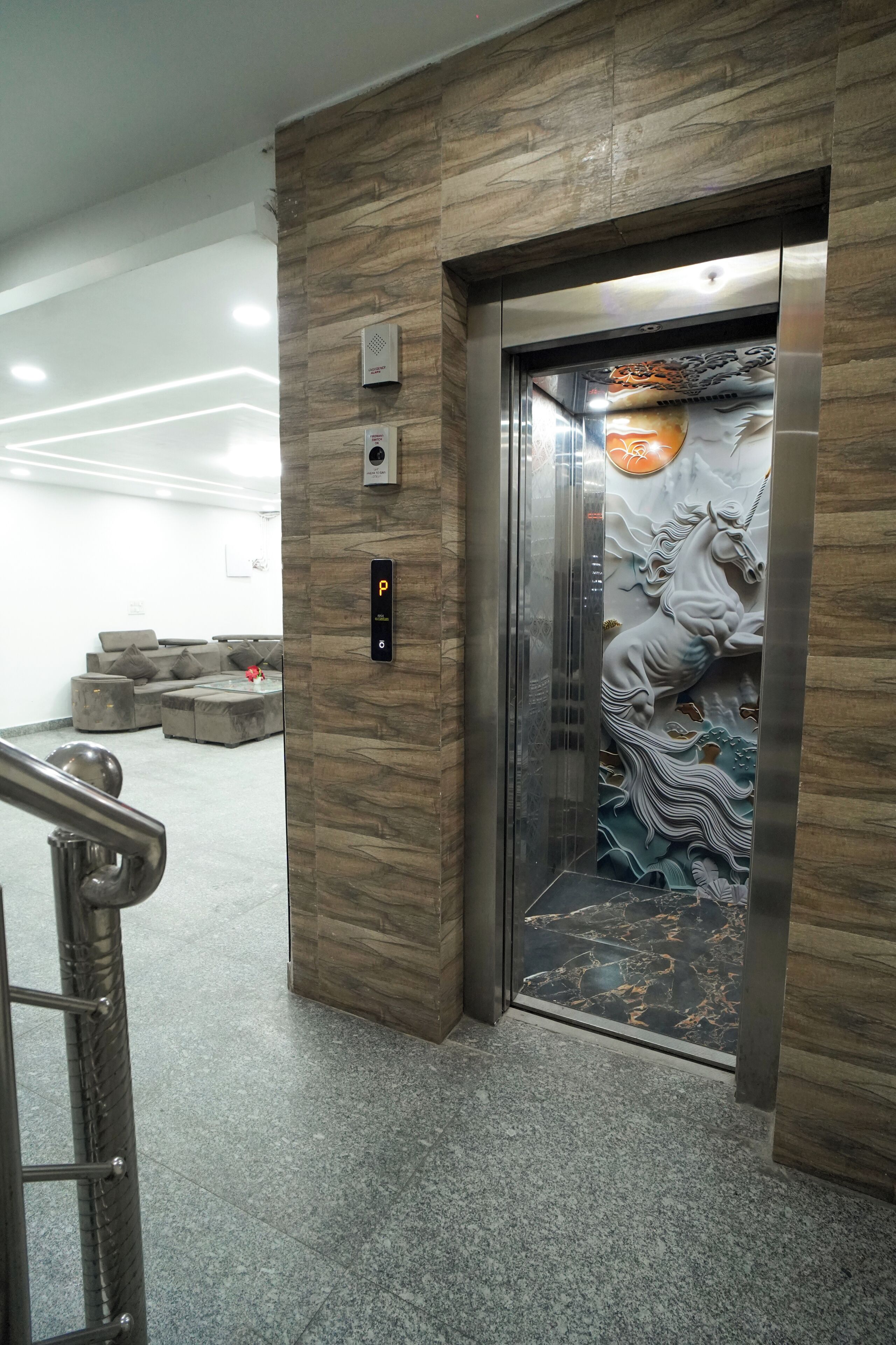An elevator with a marble wall and a decorative panel featuring a horse.