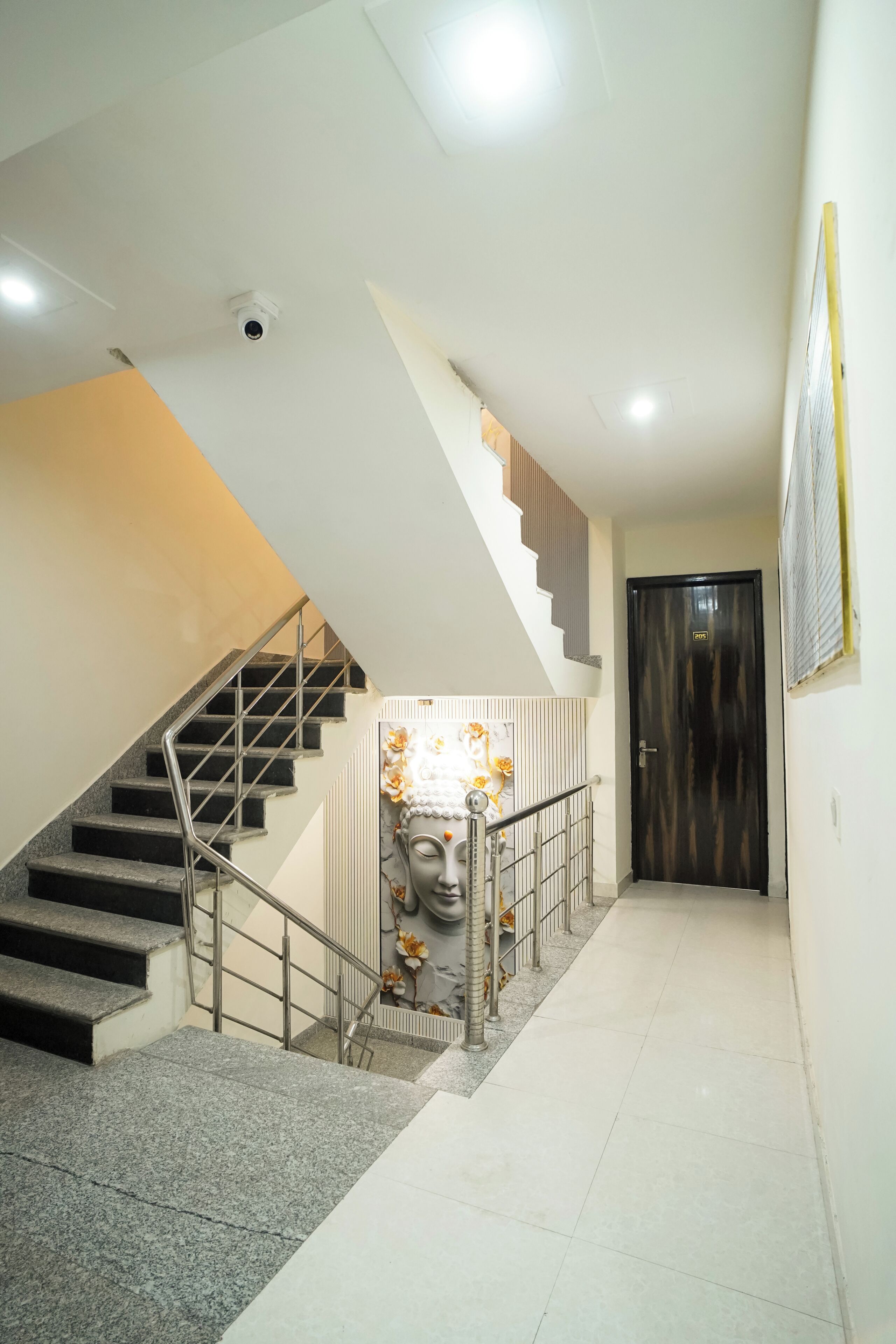 Una escalera con barandilla, una puerta con un cartel y una escultura en la pared.