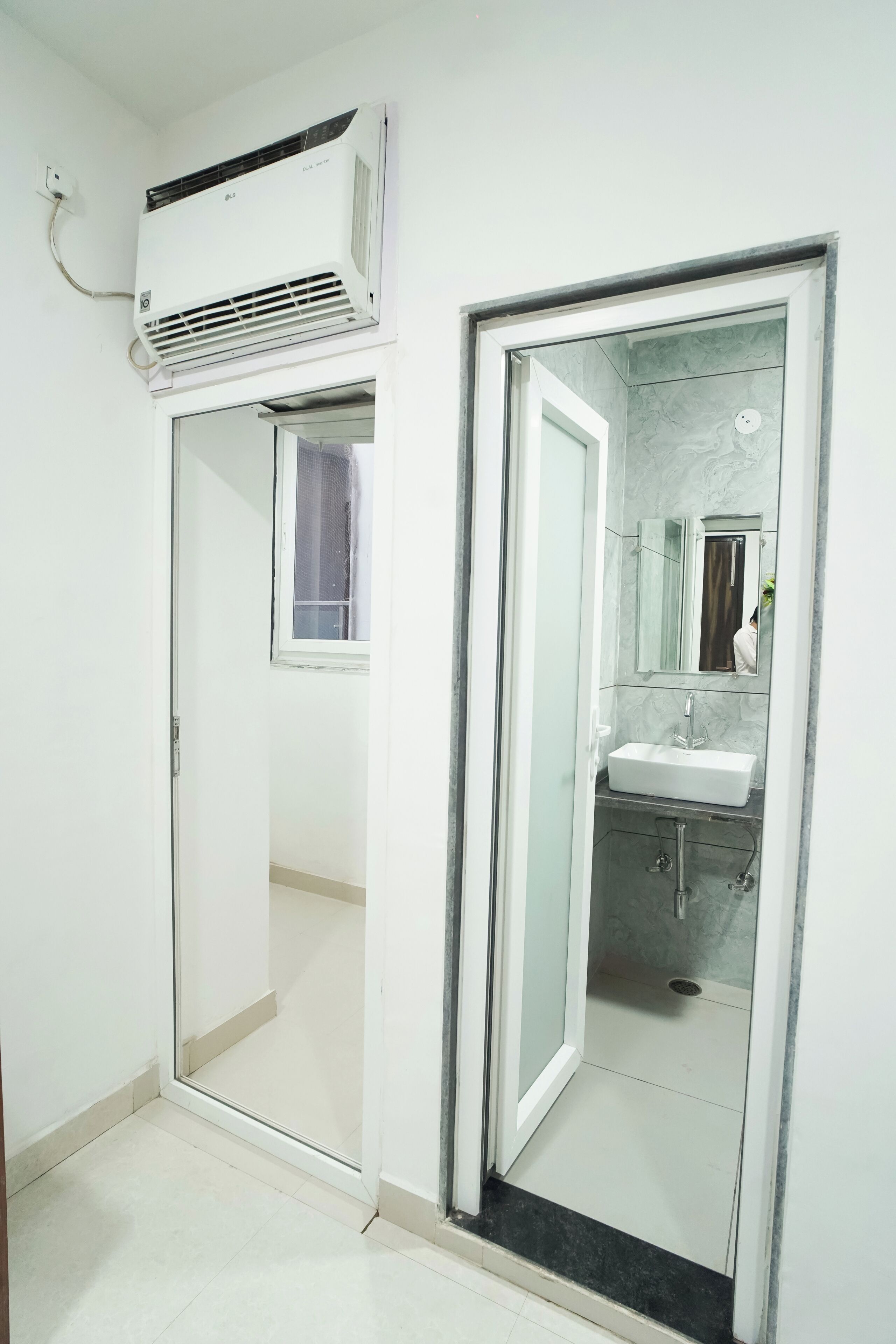 A bathroom with a glass shower enclosure, a sink, and a mirror.