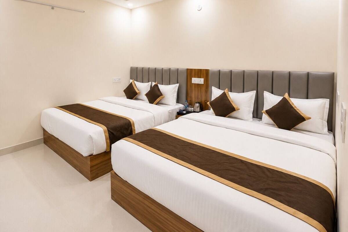 Habitación de hotel con dos camas, ventilador de techo e iluminación empotrada.