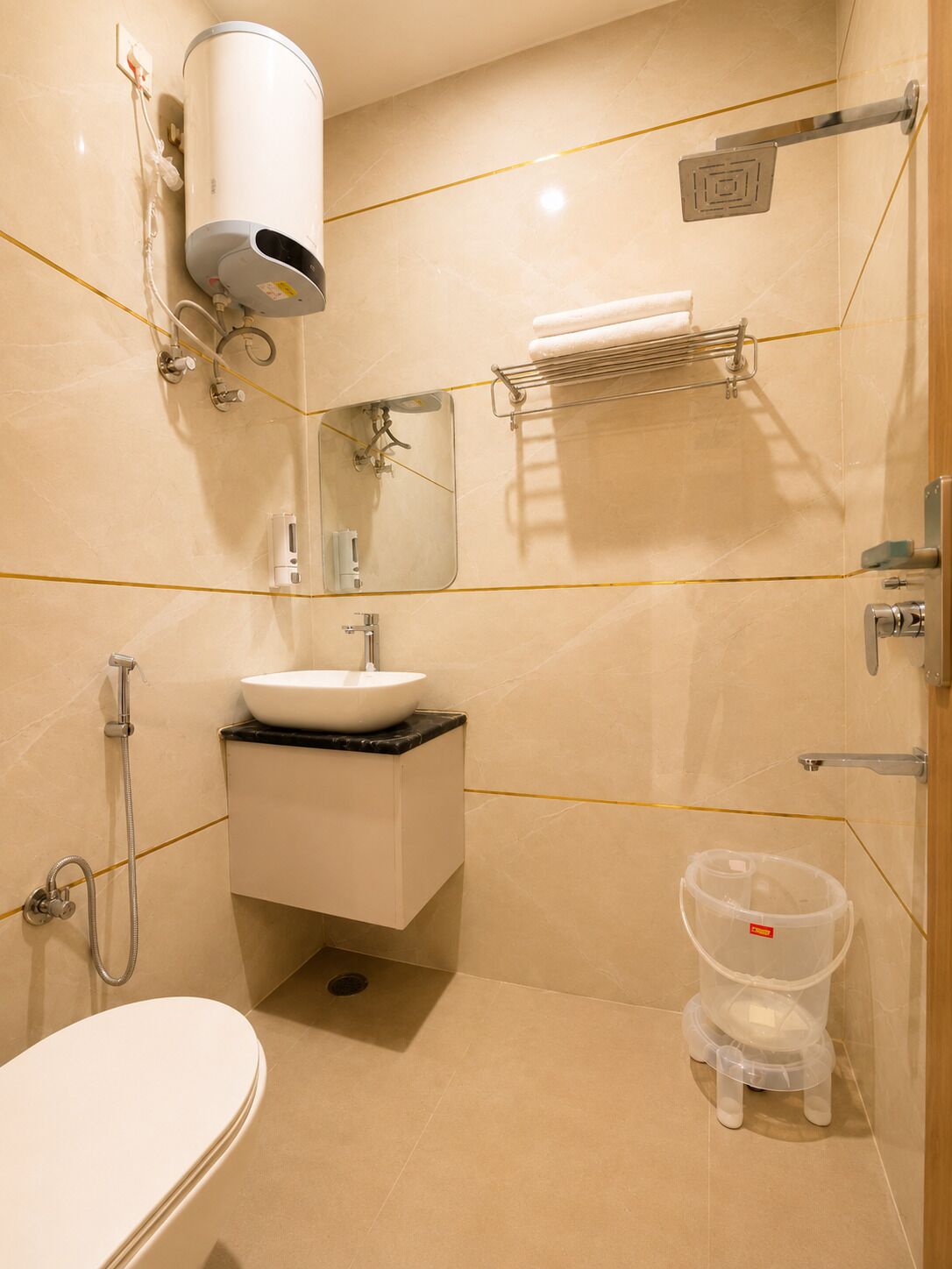Une salle de bain avec un lavabo blanc, un miroir, un porte-serviettes et une douche.