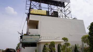 A building with a sign for 'NEENDAR HERITAGE RESORT' and a balcony with a railing.