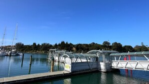 A marina with docked boats, a covered walkway, and a clear blue sky.