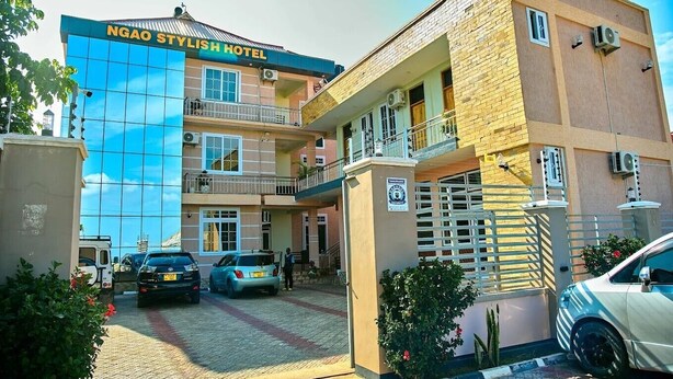 Un hôtel doté d’une façade moderne, de nombreux balcons et d’une entrée sécurisée par un portail.