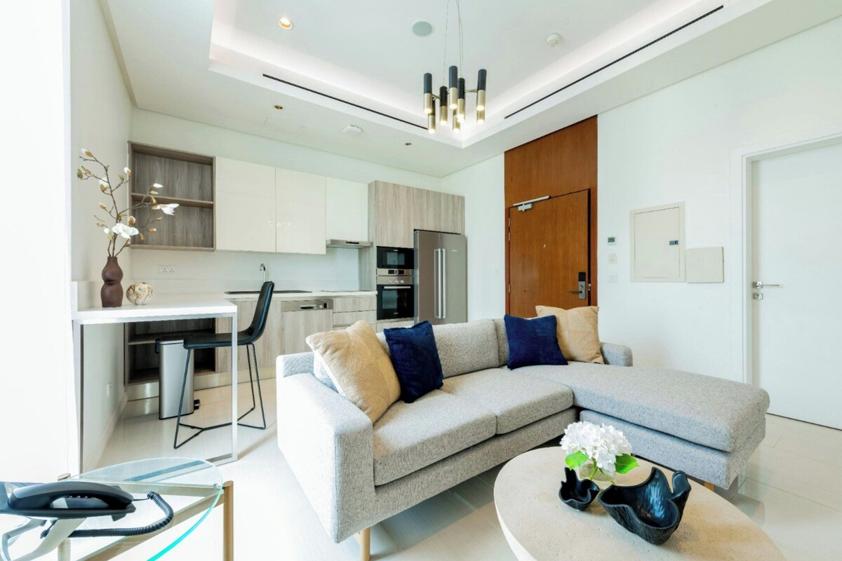 A modern living room with a sofa, a coffee table, and a dining area.