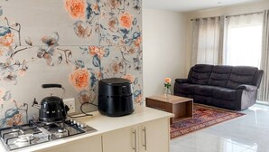 A modern kitchen with a gas stove, a coffee maker, and a black electric kettle. - The Gracewood Sanctuary - Your Peaceful Hideaway (Johannesburg)