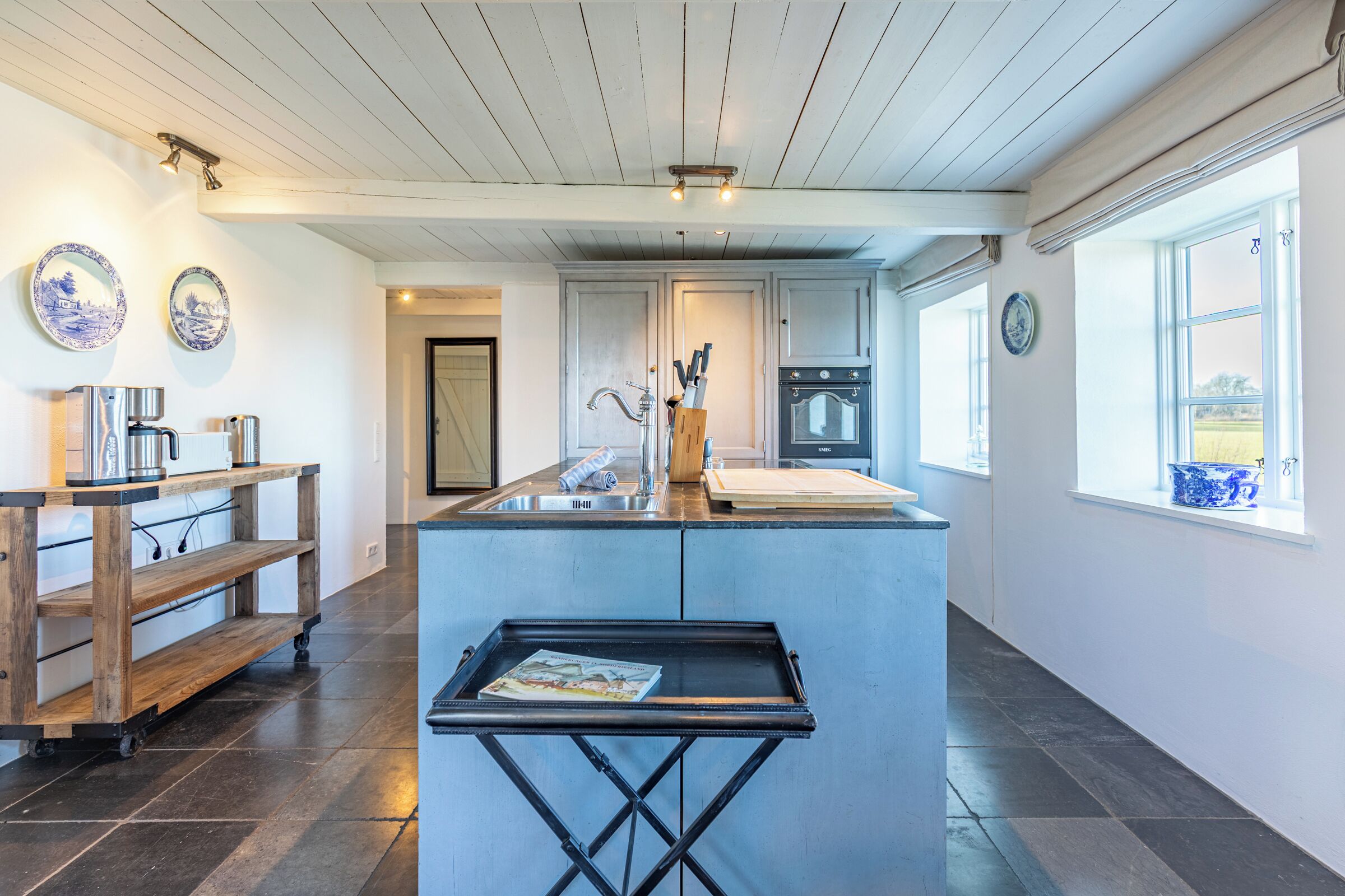 A kitchen with a central island, a sink, and a window with a view.