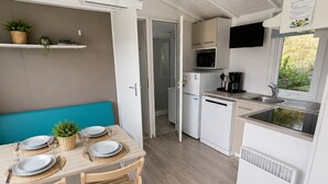Eine kleine Küche mit Mikrowelle, Kühlschrank und Spüle.