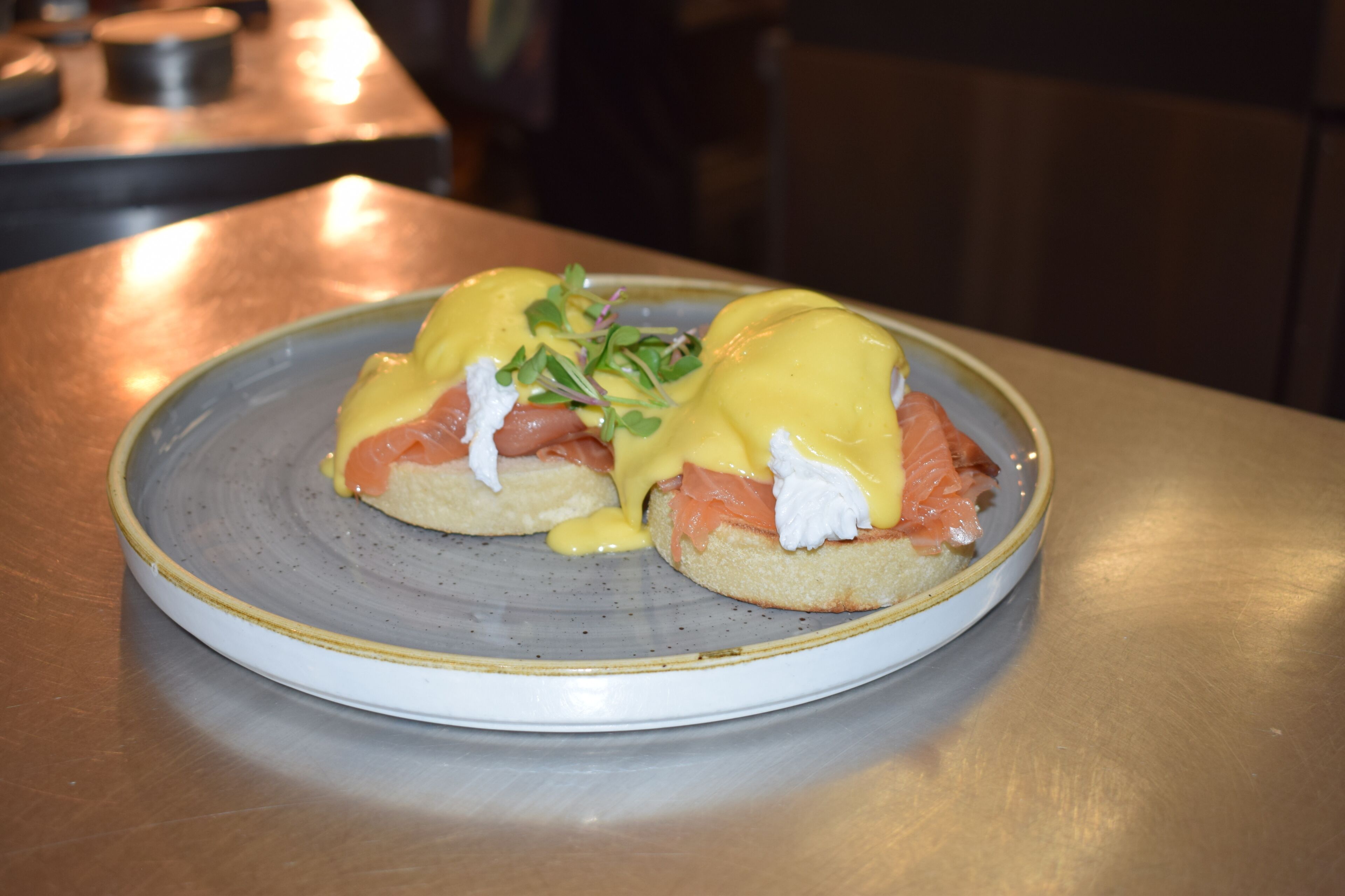 A plate with eggs benedict on a ceramic plate.
