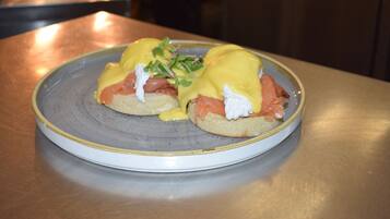 A plate with eggs benedict on a ceramic plate.