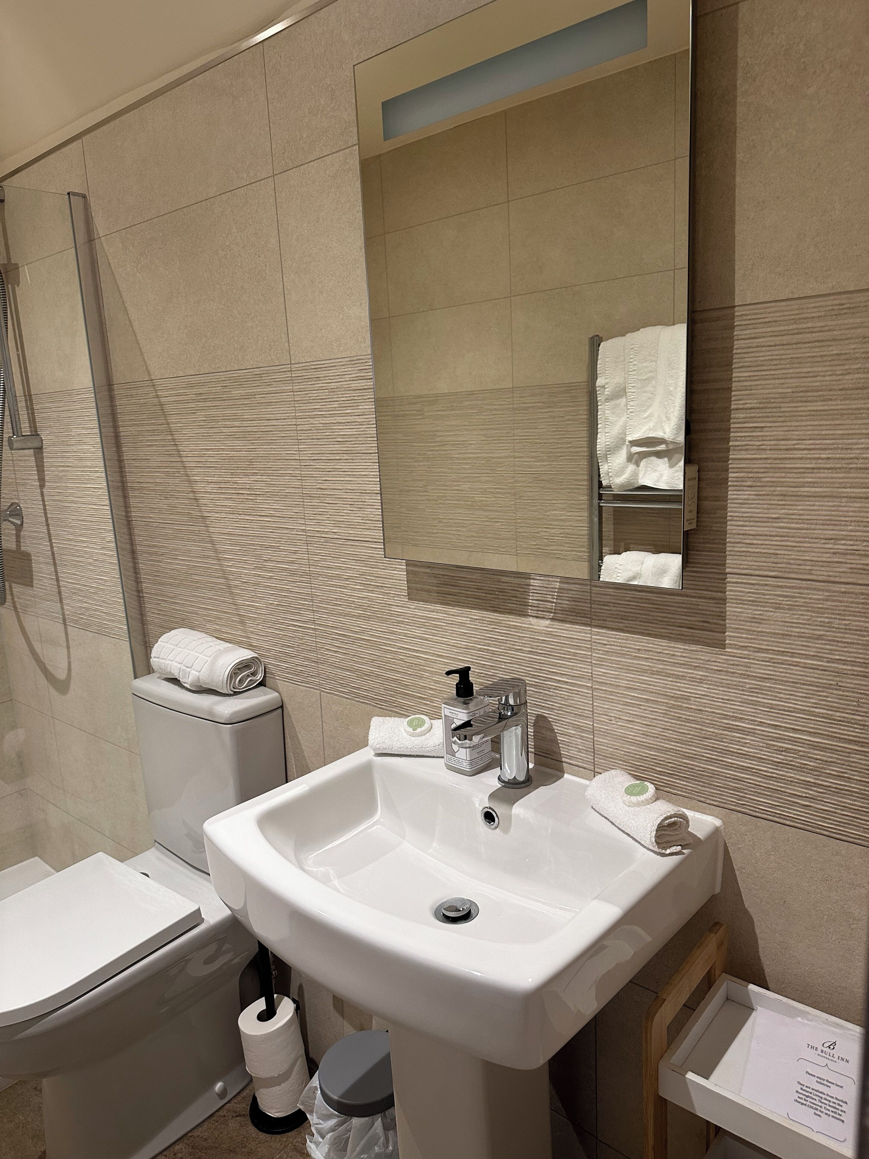 A bathroom with a sink, toilet, and shower.