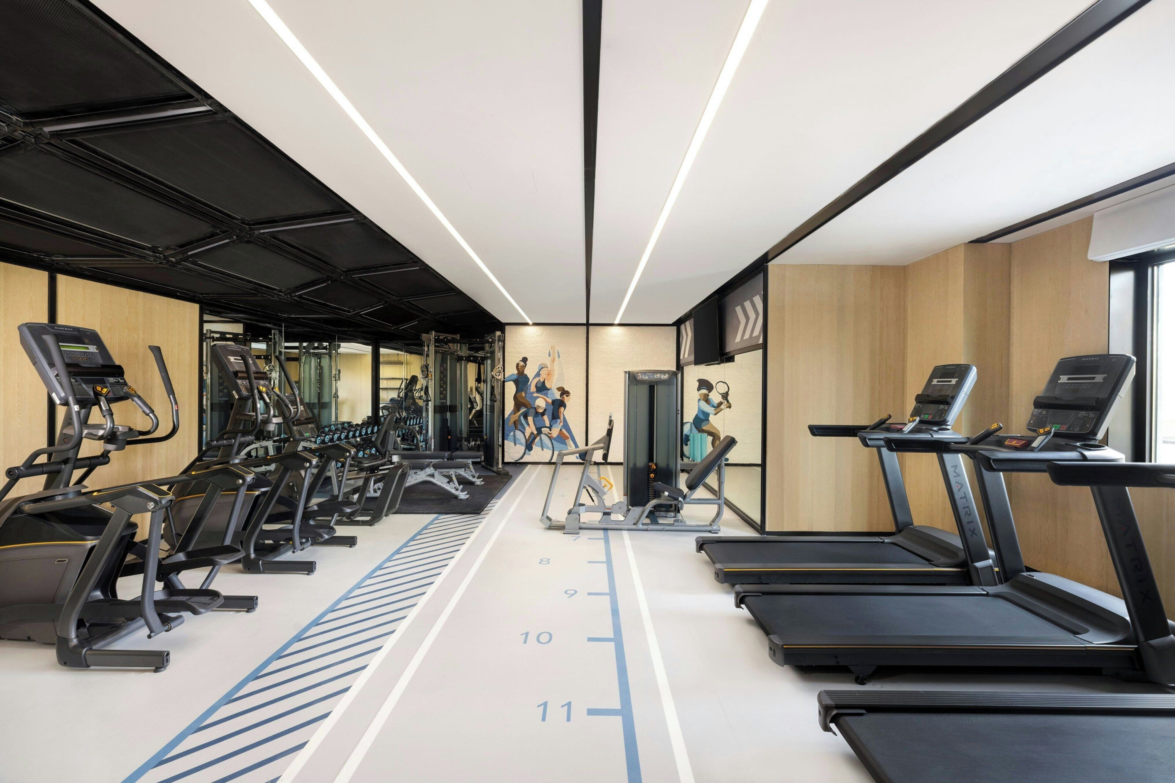 A gym with treadmills, elliptical machines, and weight equipment.
