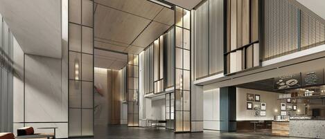 A spacious lobby with a reception desk, seating area, and a coffee bar.