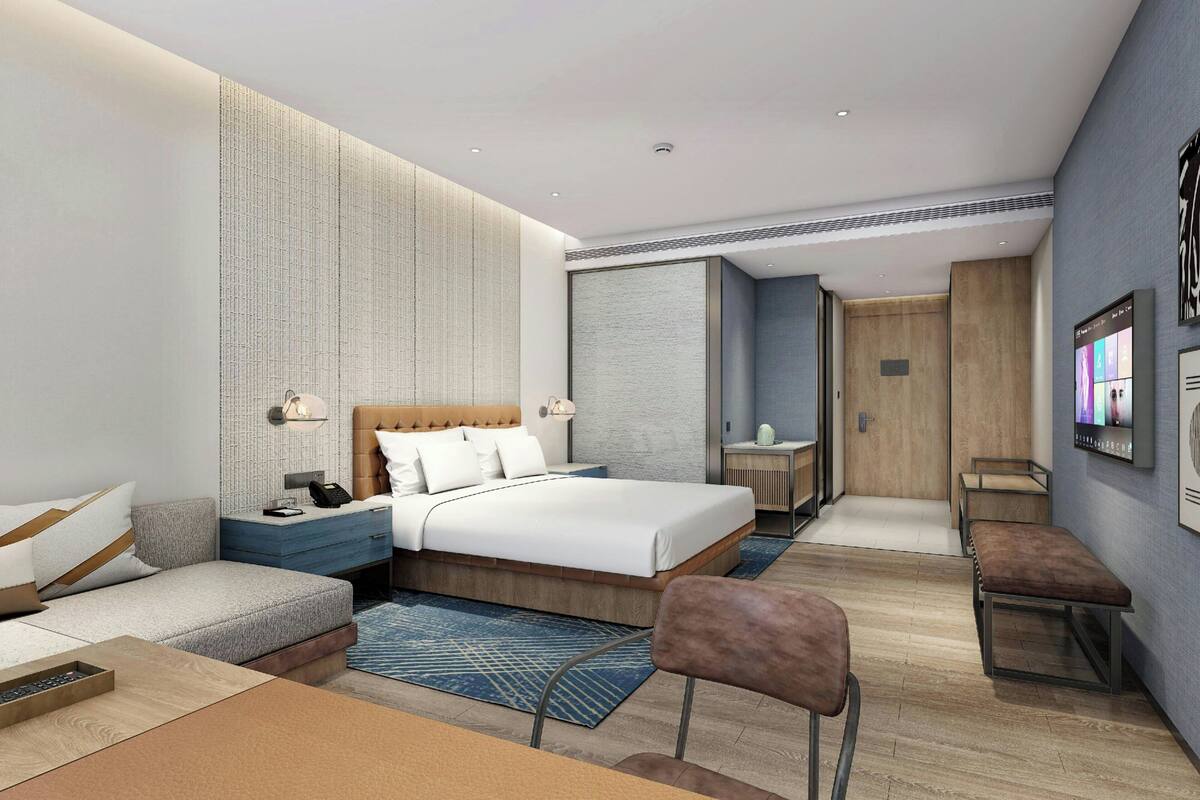 Een moderne hotelkamer met een groot bed, een zithoek, een bureau en een televisie.