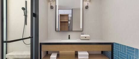 A modern bathroom with a shower, a sink, a mirror, and a towel rack.