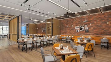 Un restaurante moderno con paredes de ladrillo, mesas y sillas de madera.