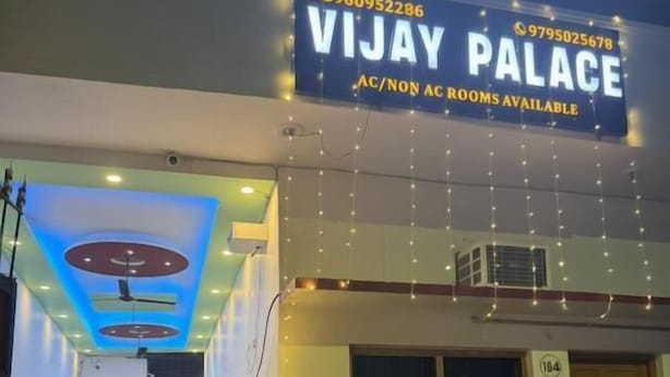 A hotel entrance with a sign reading 'VIJAY PALACE' and contact numbers. - Hotel Vijaya Palace (Ayodhya)
