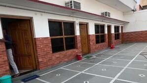 A building with a covered parking area, multiple doors, and windows. - Hotel Vijaya Palace (Ayodhya)