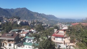 A town with buildings, a mountain, and a clear sky. - Marvelous 2-bedroom house in Solan perfect for a relaxing getaway (Solan)